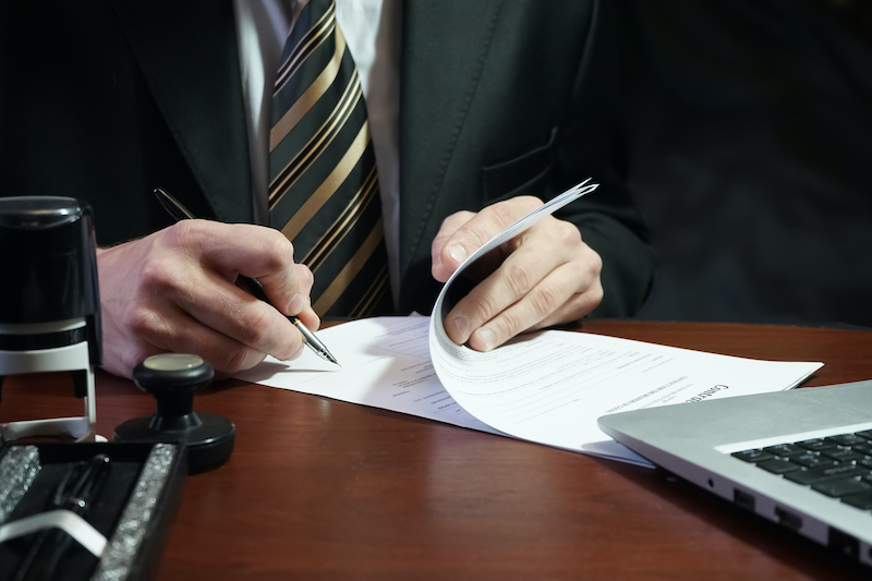 Lawyer Signing Documents At Desk