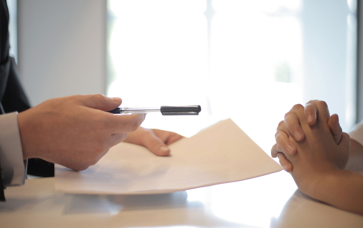 Probate Attorney Handing Their Client Paperwork And A Pen